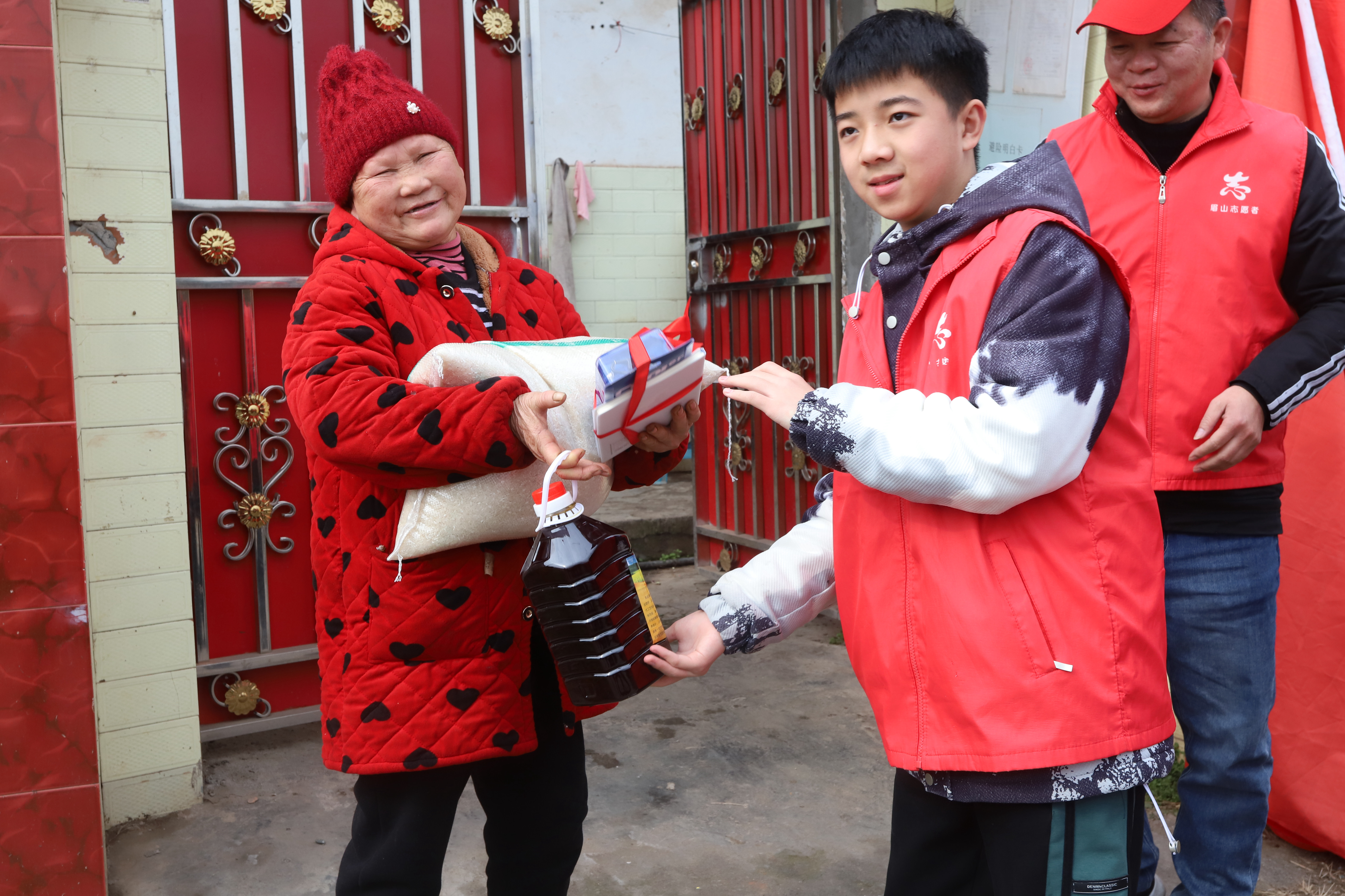 8志愿者在为孤儿陈杰的奶奶送大米菜油等春节慰问品。.JPG